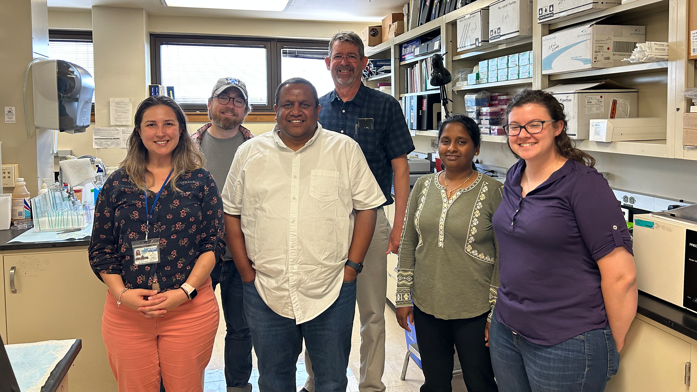 Several people pose for a photo in a research lab. 